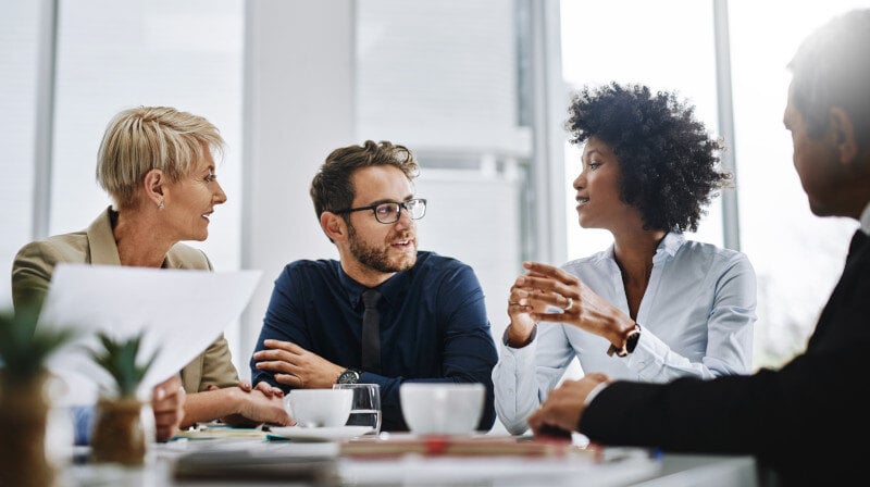 group of businesspeople sitting together in a meeting